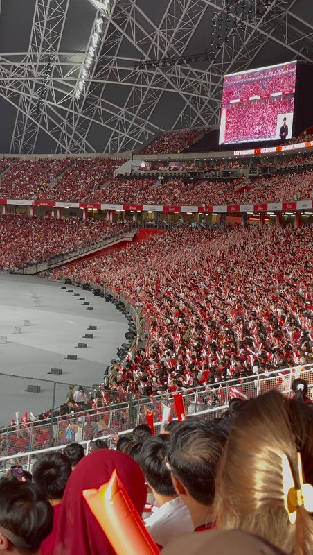 Crowds dressed in red and white gather to watch Singapore's National Day Parade, one of the country's largest annual celebrations.