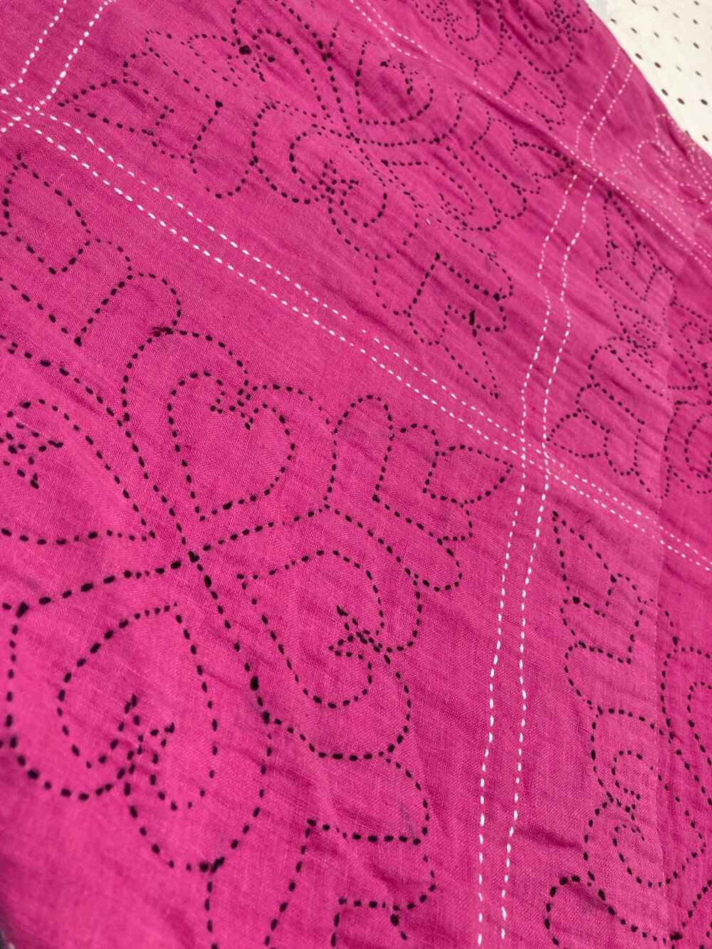 Nakshi Kantha, a traditional quilt made by layering old saris and decorating them with intricate embroidery.
